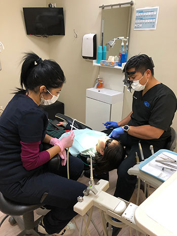 Dr. Reyes works on a patient receiving general dentistry services at North Shores Dental in Toronto Canada.