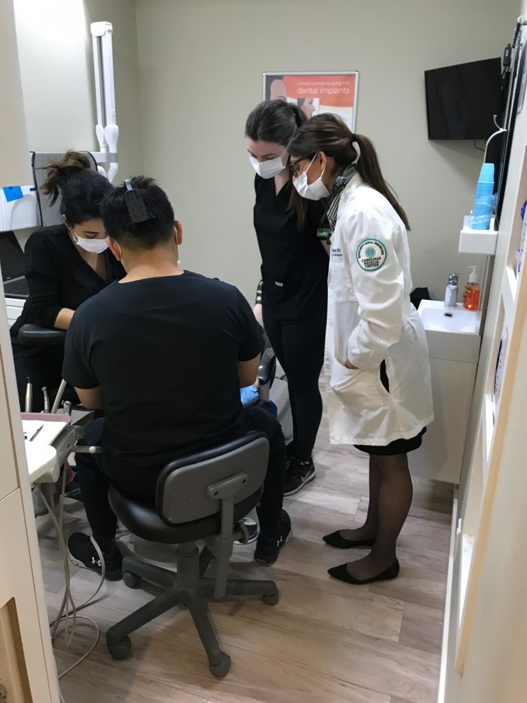 Dr. Reyes and members of his staff working in a patient who normally receives dental services at North Shores Dental in Toronto, Ontario.
